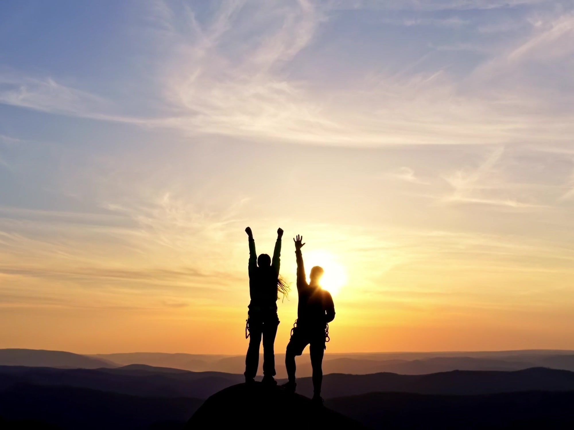 Two people celebrating together at sunset